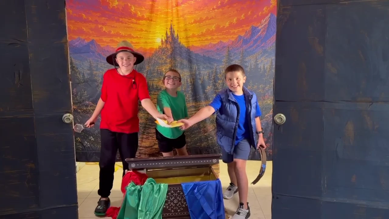 Jack, Billy and Harry beside an open Adventure chest in front of a painted mountain world.