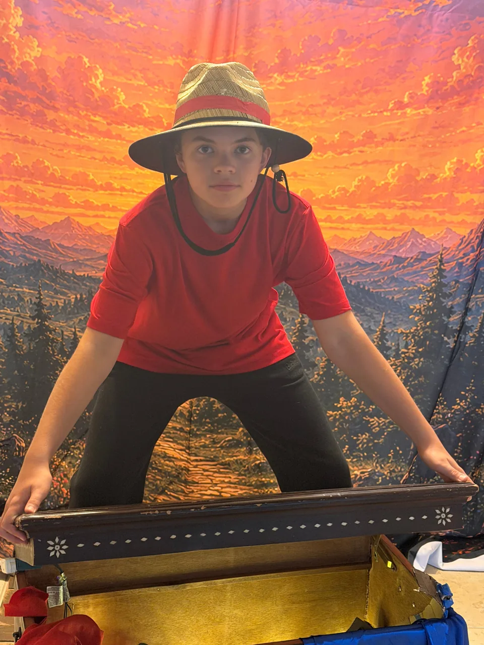 Jack, the Explorer, standing behind an open wooden chest.